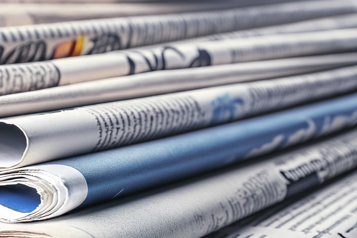 A stack of rolled and folded newspapers.