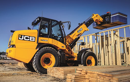 A bright yellow JCB branded telescopic wheel loader lifting building materials on a construction site. 